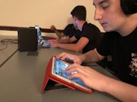 a young man using an ipad with headphones