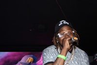a man in a hat is singing into a microphone