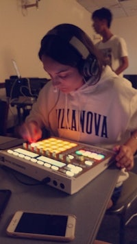 a woman using a midi controller in a classroom