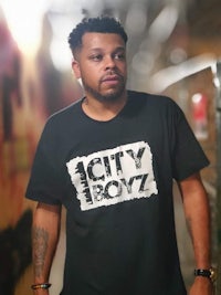a man wearing a t - shirt that says city boyz